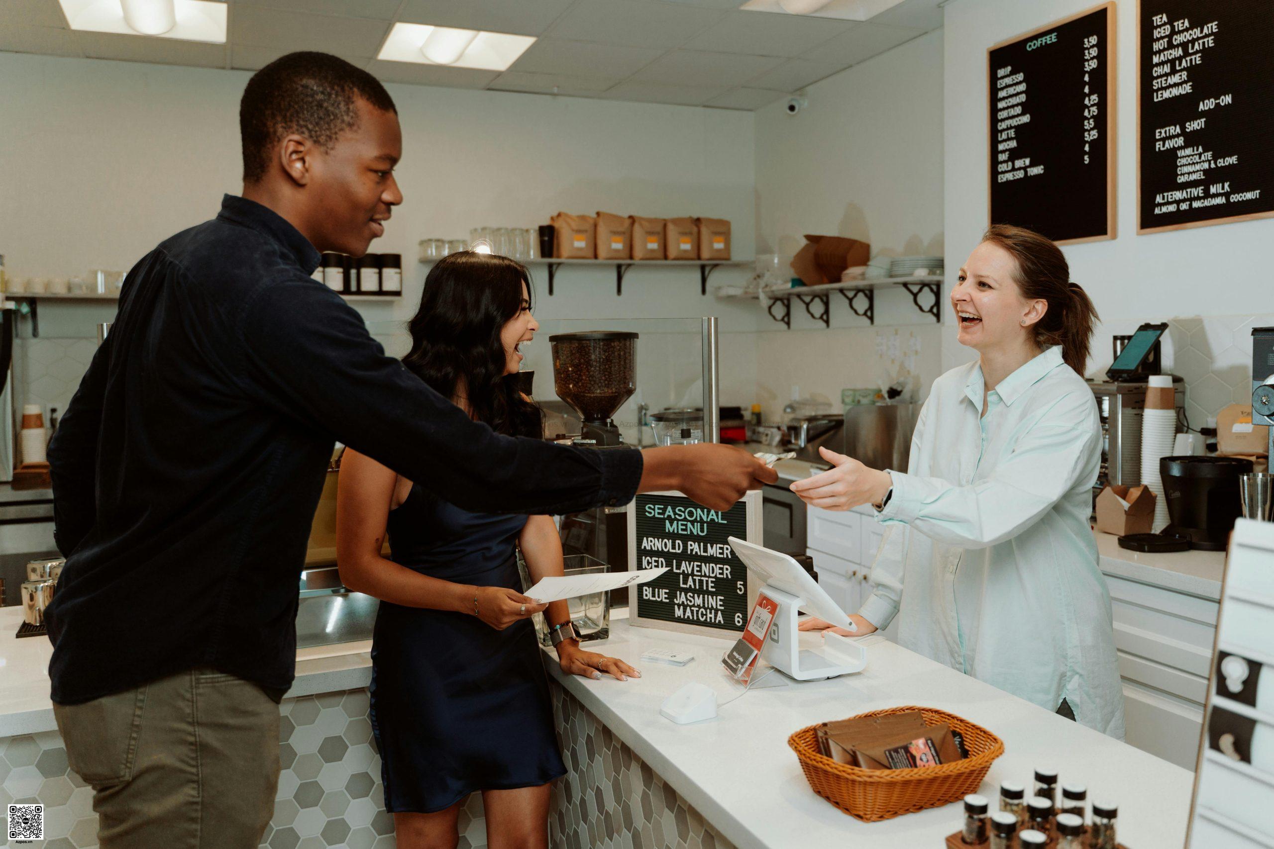 Khách và barista giao tiếp vui vẻ tại quầy – tăng trải nghiệm và giữ chân khách quán cafe