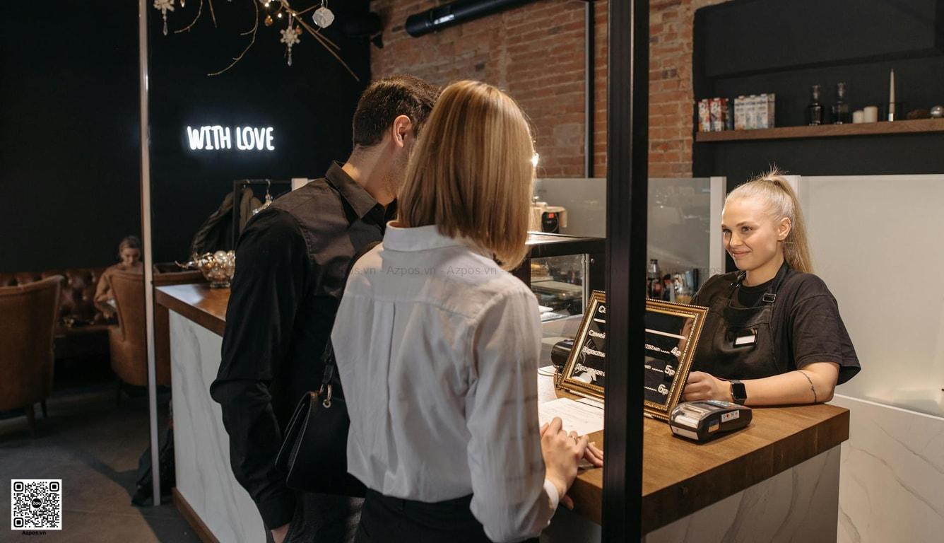 Quầy thu ngân quán cafe với máy POS và thao tác thanh toán
