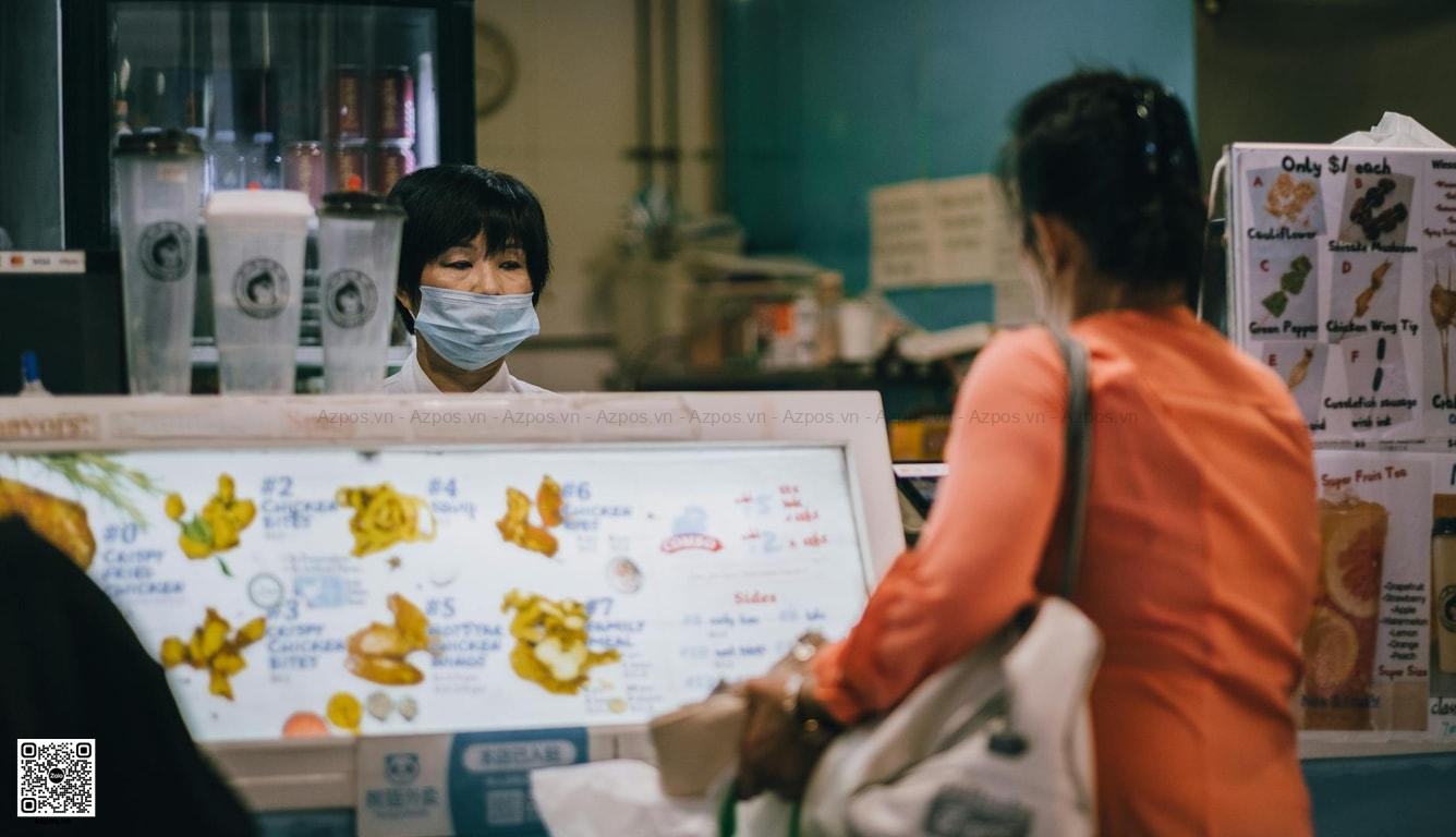 Thu ngân quán đồ uống xử lý thanh toán tại quầy