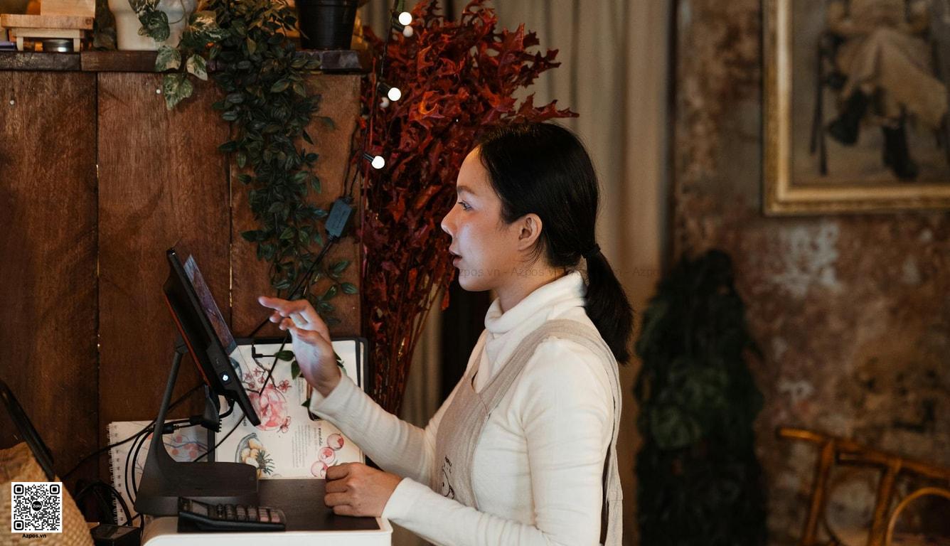 Chủ cửa hàng thao tác máy POS tại quầy thanh toán
